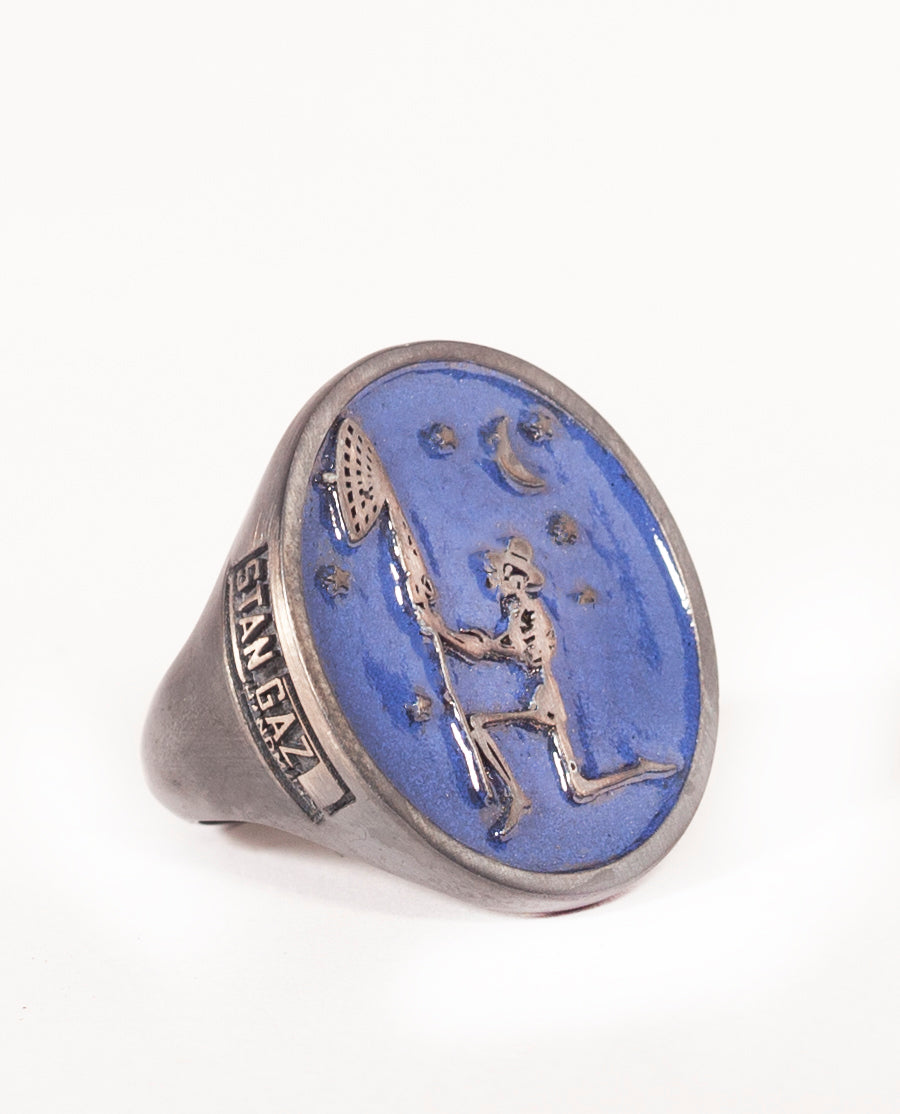 Silver skeleton blue enamel signet ring with side logo and custom patina.